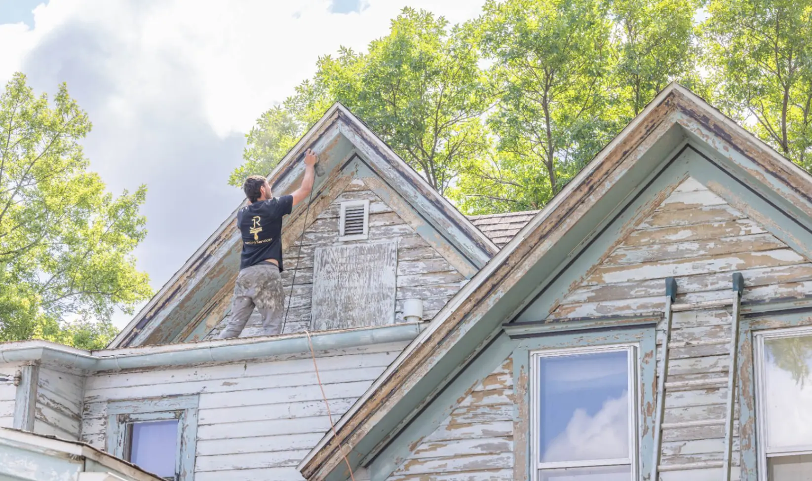 JR Painting crew prepping and repainting weathered exterior siding on a two-story home